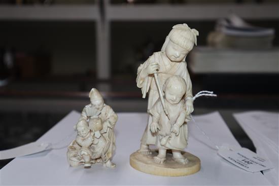 A Meiji carved ivory group of two children (damaged) on hardwood stand and a smaller group tallest 14cm incl. stand